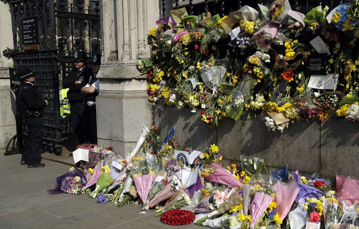 Floral tributes to the victims of the Westminster terrorist attack placed outside the Palace of Westminster, London, Monday March 27, 2017. Attacker Khalid Masood is believed to have used the messaging service WhatsApp before running down pedestrians on Westminster Bridge and storming a gate outside Parliament armed with two knives, Wednesday. Four died in the rampage, including a police officer. (AP Photo/Matt Dunham)
