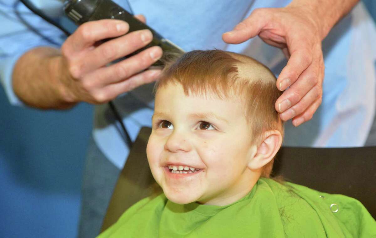 William LeBrando, 2 1/2 and from New Milford, gets the clippers for the first time from Hair Studio owner William Zane, as he smiles at his mom during the Team Brent St. Baldrick's event on Sunday at the Westport Family YMCA. More than 200 people came through and had the hair cut for the event, it is the top fundraising event in Connecticut, having raised more than $3 million. This event was started 12 years ago by Mike and Dana McCreesh to honor their son, Brent, who endured a battle with cancer that started with a neuroblastoma diagnosis at 2 years old. Today Brent is a healthy and active teenager.
