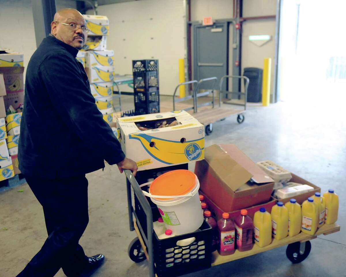 Elwood Powell Jr., regional director of 820 River Street Inc., wheels out food that he'll give to the roughly 75 people in drug addiction recovery programs. The organizaition is one of many that rely on the Regional Food Bank, in Colonie, N.Y. for fresh food and other materials. (Robert Downen/Times Union)