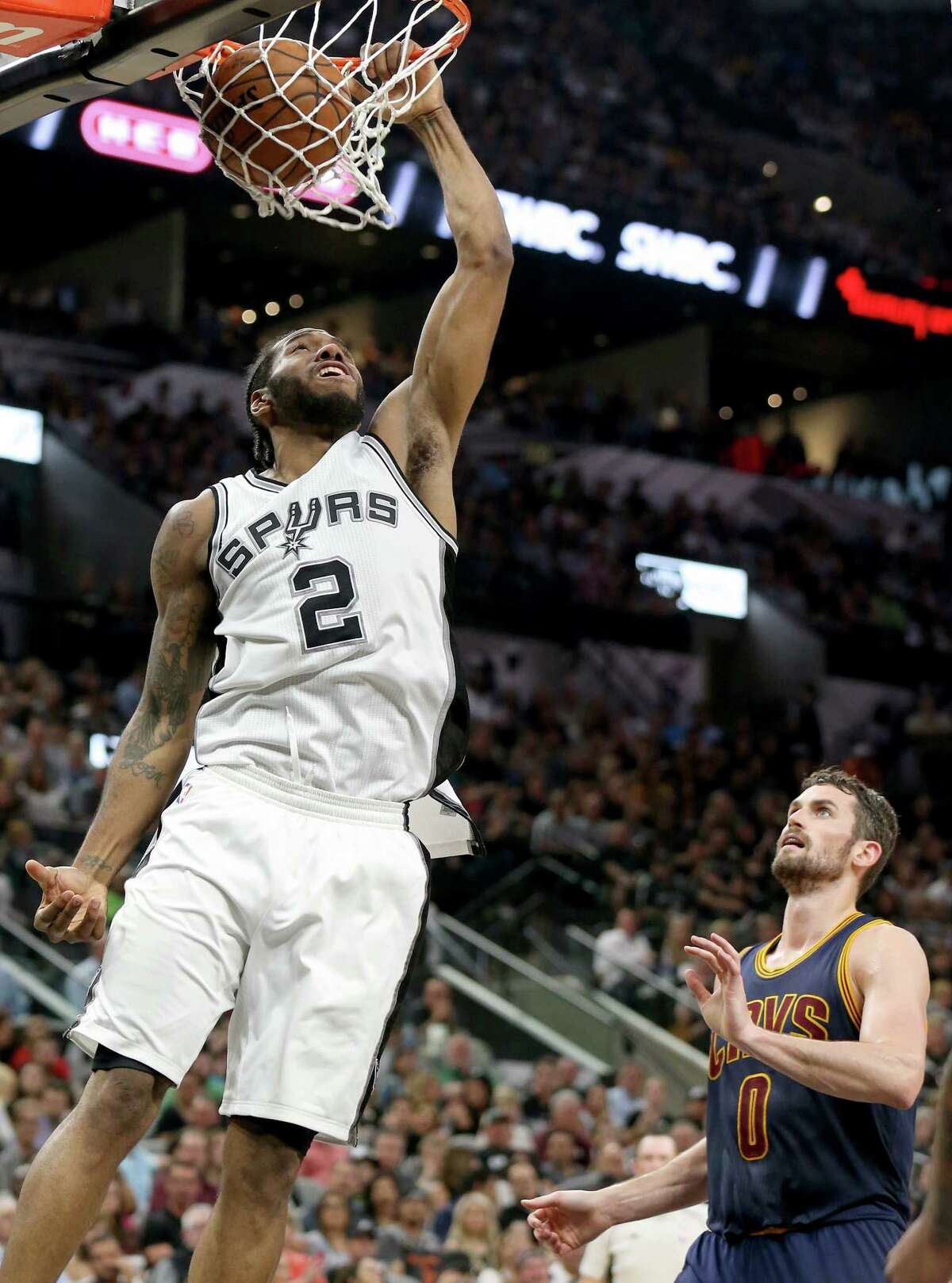 San Antonio Spurs' Kawhi Leonard dunks around Cleveland Cavaliers' Kevin Love during first half action Monday March 27, 2017 at the AT&T Center.