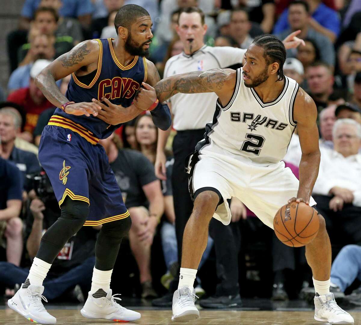 Spurs’ Kawhi Leonard looks for room around the Cleveland Cavaliers’ Kyrie Irving during second half action on March 27, 2017 at the AT&T Center.
