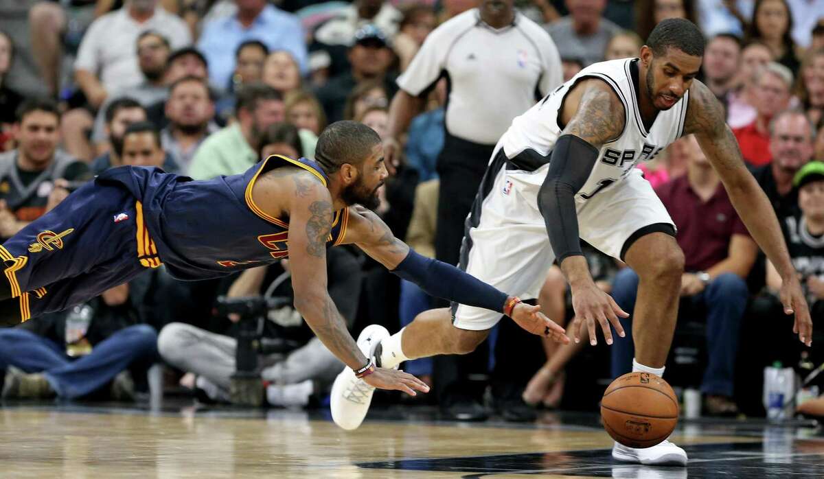 Cleveland Cavaliers’ Kyrie Irving and the Spurs’ LaMarcus Aldridge chase after a loose ball during first half action on March 27, 2017 at the AT&T Center.
