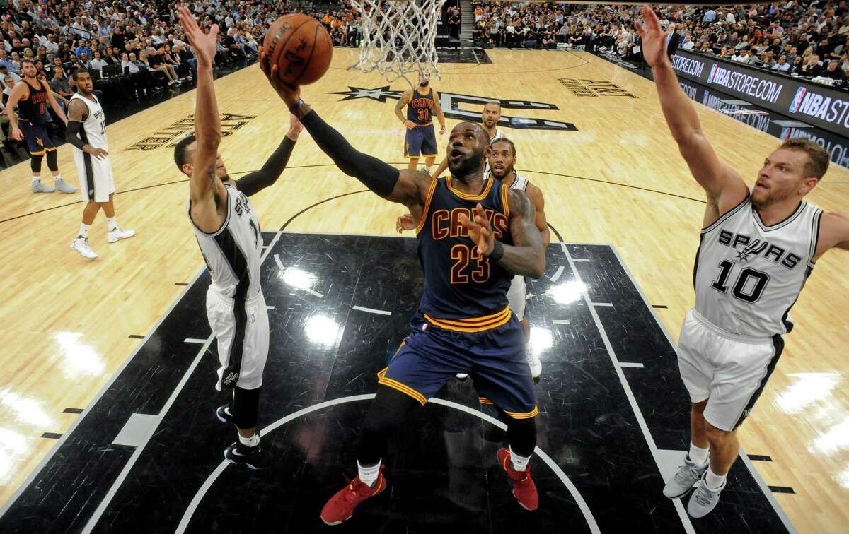 Cleveland Cavaliers’ LeBron James shoots between the Spurs’ Danny Green and David Lee on March 27, 2017 at the AT&T Center. The Spurs won 103-74.