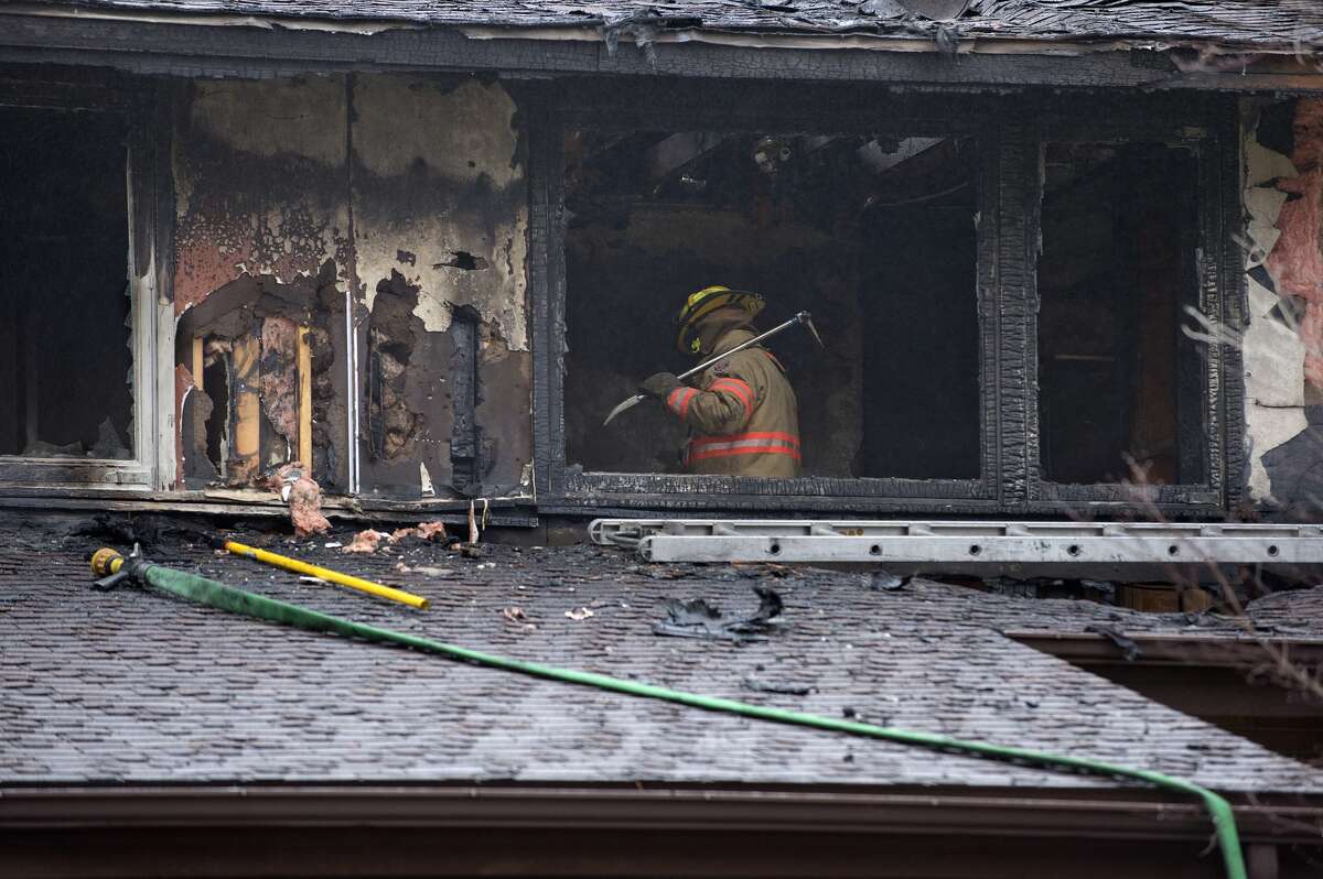 BRITTNEY LOHMILLER | blohmiller@mdn.net Midland firefighter inspects 3108 Applewood after responding to a fire Tuesday morning. No one was injured in the fire which started on the second floor and spread. Midland Police, MidMichigan Medical Center EMS and Consumer Energy also responded.