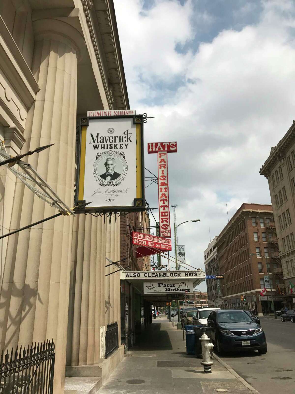 A sign tantalizes downtowners with the news that Maverick Whiskey is coming soon. The sign hangs over the old Antiques on Broadway space, right next door to the famous Paris Hatters shop.