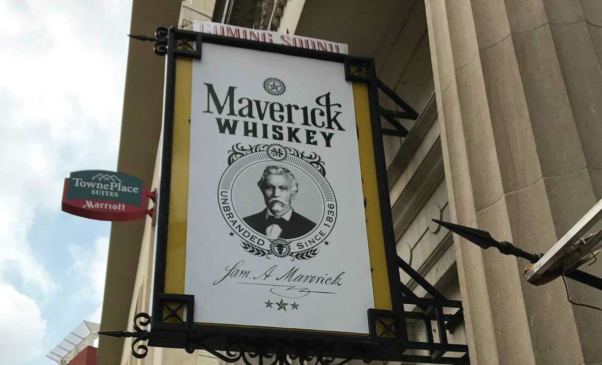 A sign tantalizes downtowners with the news that Maverick Whiskey is coming soon. The sign hangs over the old Antiques on Broadway space, right next door to the famous Paris Hatters shop.