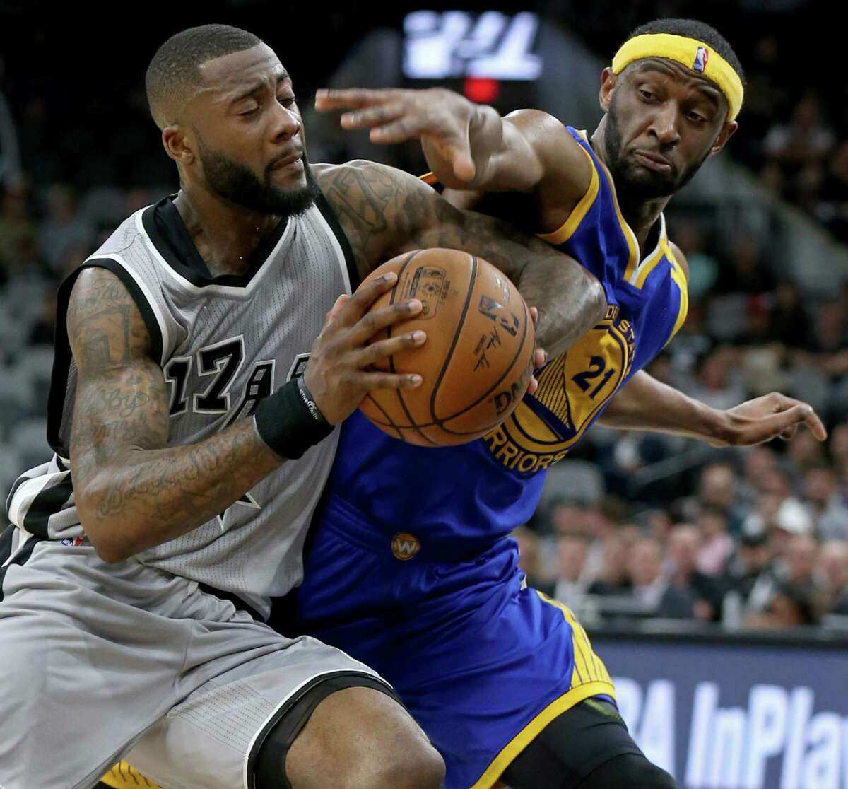Spurs’ Jonathon Simmons looks for room around the Golden State Warriors’ Ian Clark during second half action on March 11, 2017 at the AT&T Center.