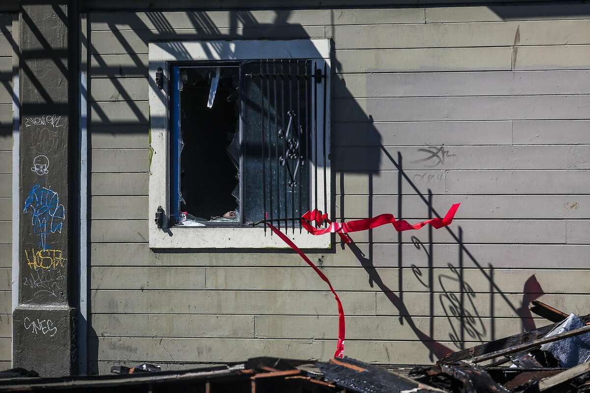 A broken window is seen in an apartment complex that was destroyed in a four-alarm fire yesterday on San Pablo Avenue in Oakland, California, on Tuesday, March 28, 2017.