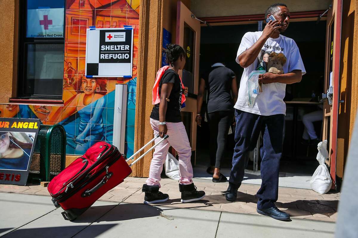 Zarinity Wherry,10, (left) brings a bag of luggage into the at the West Oakland Youth Center which is acting as a shelter for those displaced by a four-alarm fire yesterday in Oakland, California, on Tuesday, March 28, 2017. Zarinity and her family were displaced by the fire which destroyed their apartment and sent her to the hospital for smoke inhalation.