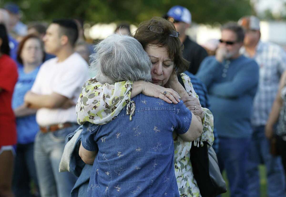 Longtime friends Jane Lorenz (right) hugs Margaret Pike who both attend St. Anne Church join the community of La Vernia during a spiritual service on Tuesday, Mar. 28, 2017 in the wake of recent events which resulted in arrests of students hazing other students in a horrific manner. The La Vernia Ministerial Alliance and La Vernia News hosted and invited community members to join in prayer and music at the La Vernia City Park on Tuesday evening. People were asked to bring messages of hope and healing in plastic Easter eggs which were exchanged during the service. (Kin Man Hui/San Antonio Express-News)