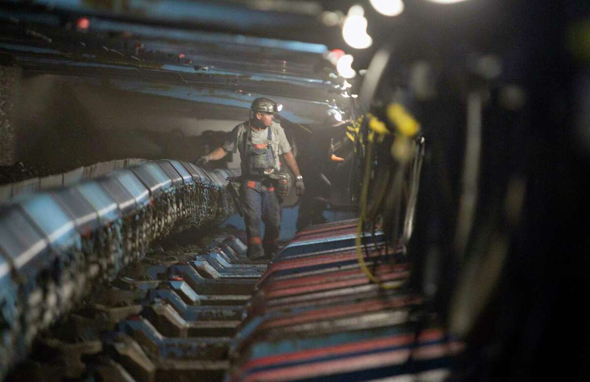 A miner passes hydraulic jacks next to a coal seam in the Pond Creek coal mine in Johnson City, Ill.