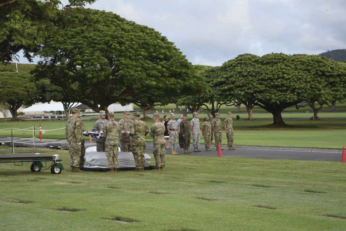 In this Jan. 22, 2017 photo provided by the National Memorial Cemetery of the Pacific members of a Defense POW/MIA Accounting Agency joint service detail in Honolulu prepare to drape the casket of an unknown serviceman killed in the Battle of Tarawa. Military and Veterans Affairs officials are digging up the remains of dozens of unidentified Marines and sailors killed on a remote atoll in the Pacific during one of World War II's bloodiest battles in an attempt to identify them. (Gene Maestas/National Memorial Cemetery of the Pacific via AP)