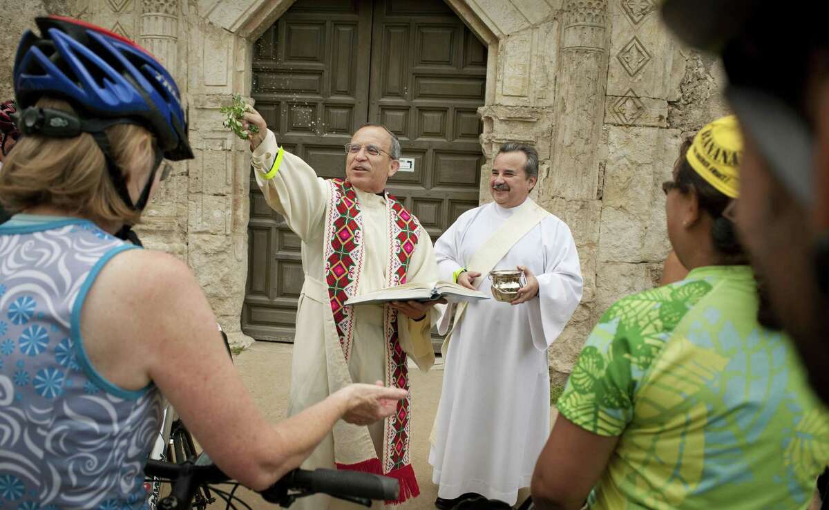 Father David Garcia blesses bicycles and riders with holy water, Sunday, May 20, 2012, at Mission Concepcion in San Antonio. (Darren Abate/Special to the Express-News)