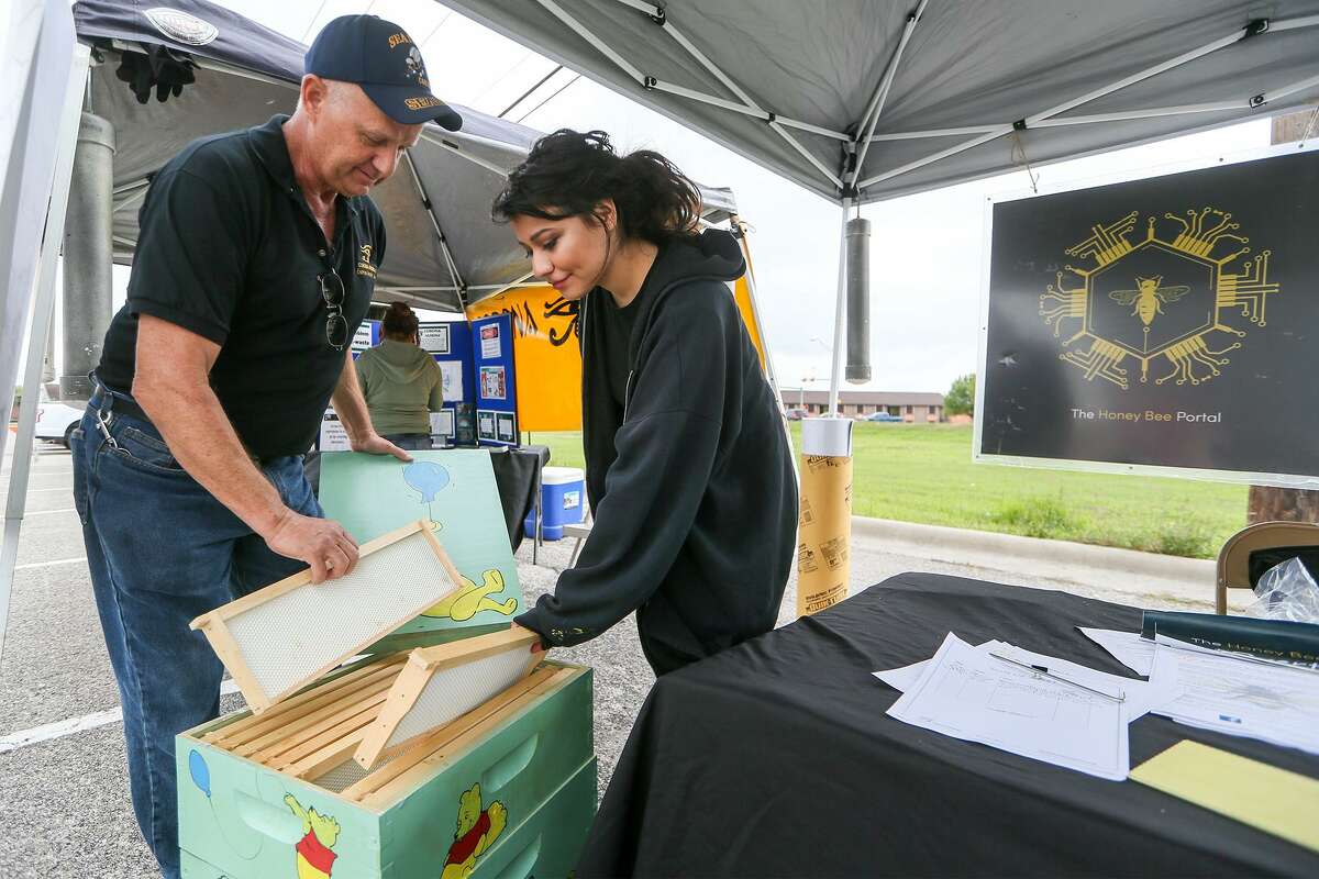 Vandell Norwood (left) and Savannah Quintana with the Urban Bee Keeping Group display the frames inside a bee hive during the sixth annual Converse Goes Green at Rutledge Stadium on Saturday, March 18, 2017.