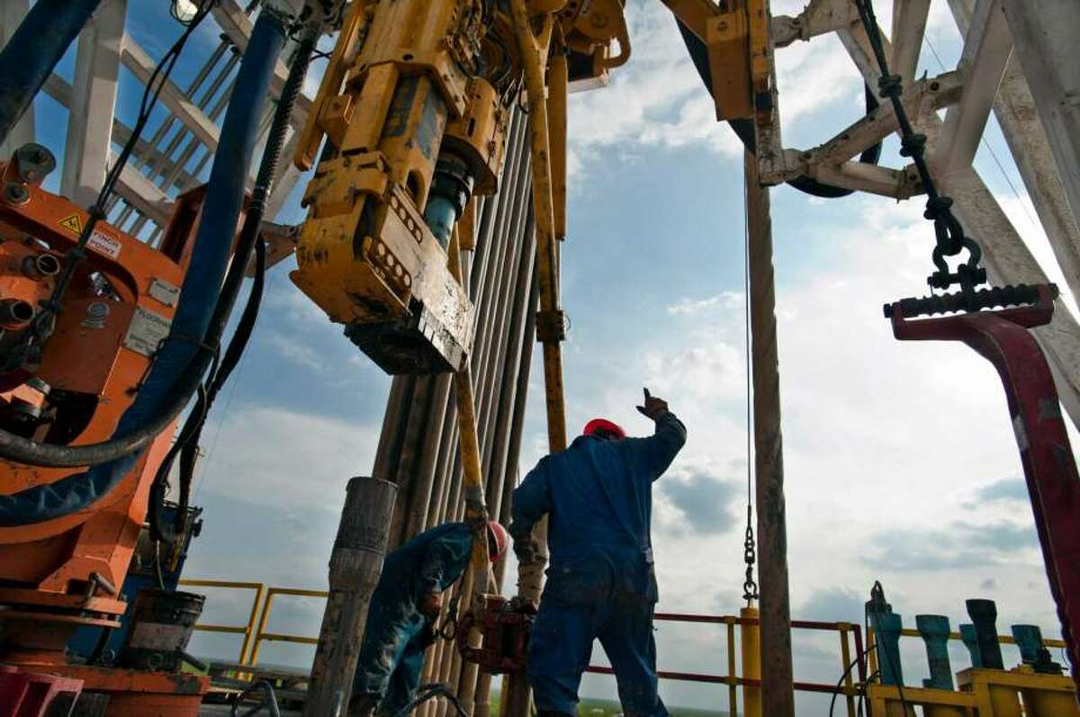 A crew works on a drilling rig in Webb County. Two recent reports point to an improved oil patch outlook.