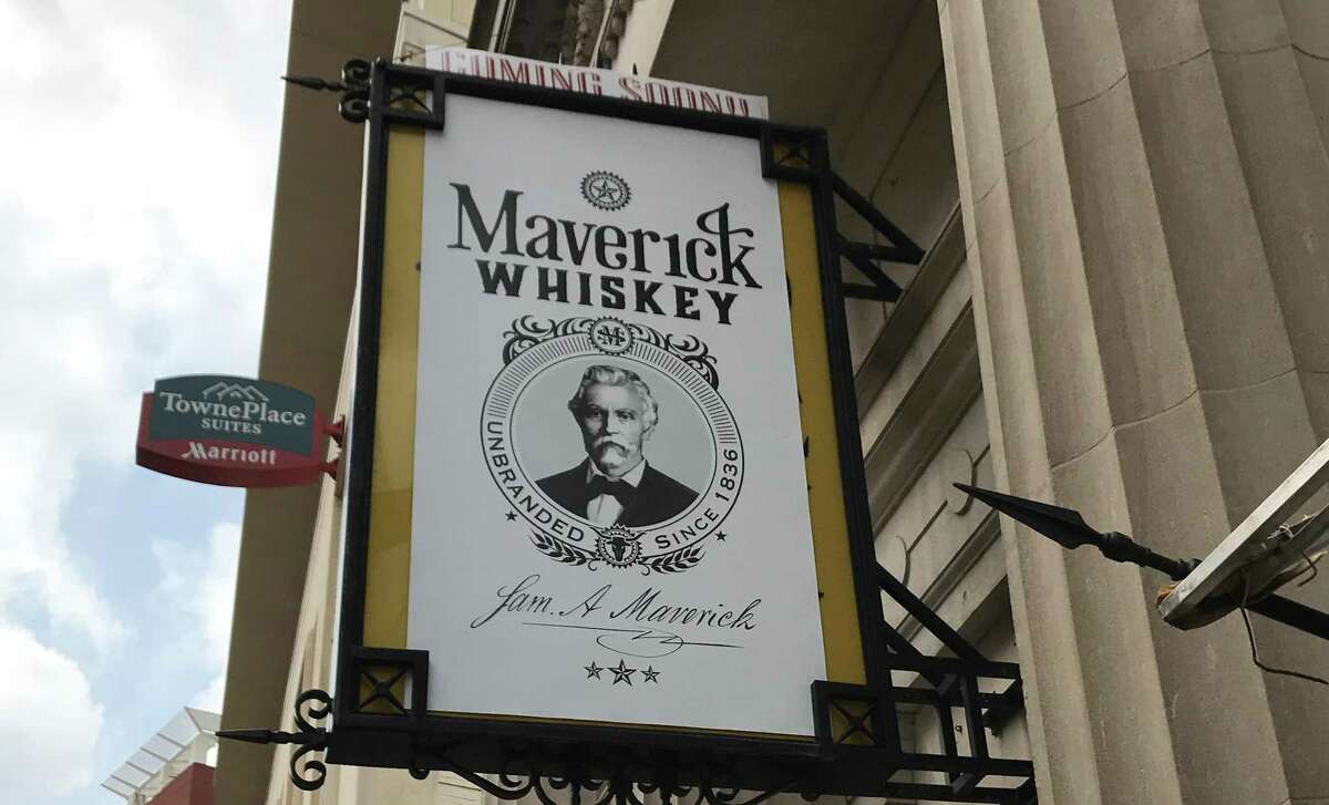 A sign tantilizes downtowners with the news that Maverick Whiskey is coming soon. The sign hangs over the old Antiques on Broadway space, right next door to the famous Paris Hatters shop.