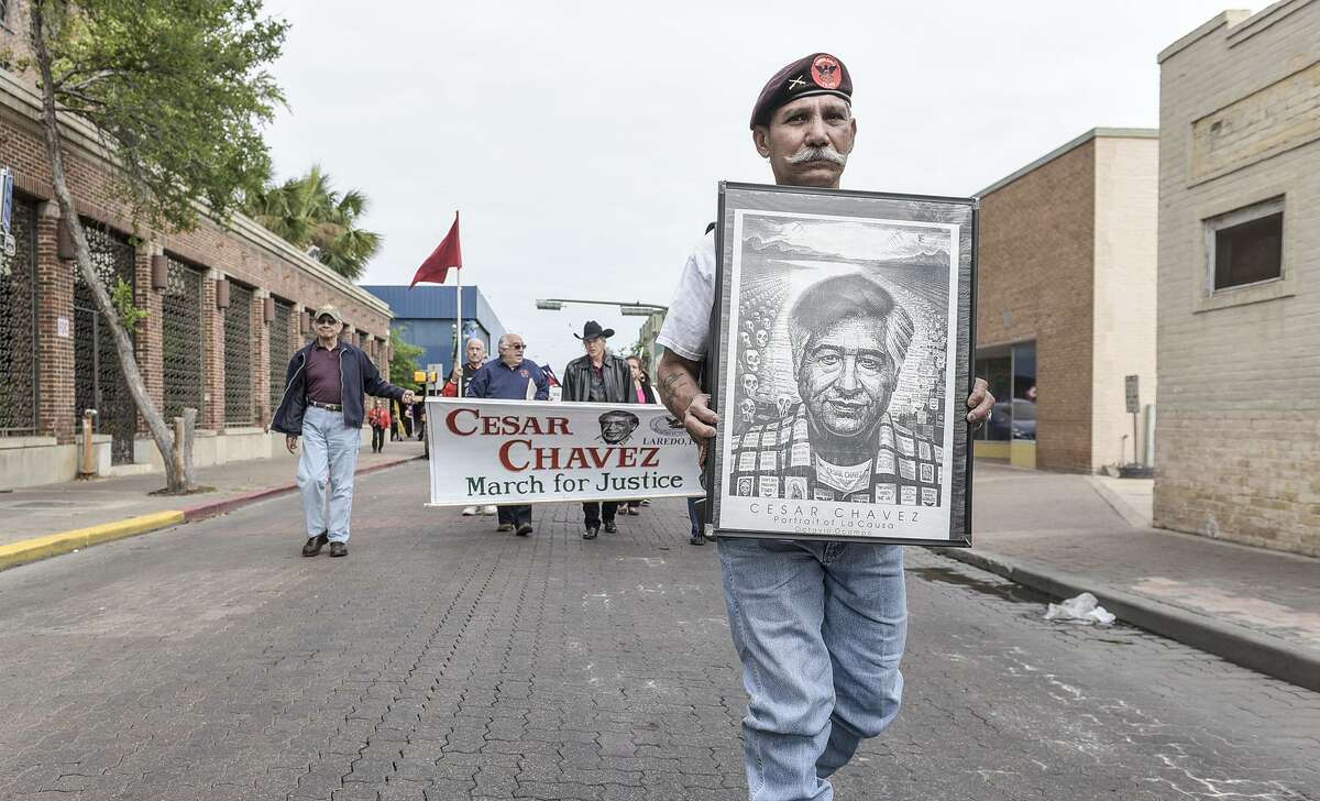 In this March 2016 file photo, Esmeraldo Pruneda holds a poster of Cesar Chavez as he leads a procession down Hidalgo Street during the Cesar Chavez March for Justice. Pruneda was a security guard for Chavez in the 1960s.