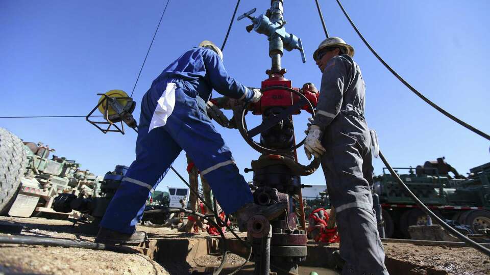 Oil field workers for Pioneer Natural Resources help frack a well in an oil field south of Midland. Pioneer has added nearly 3 million lateral feet in the Permian by trading acreage with 