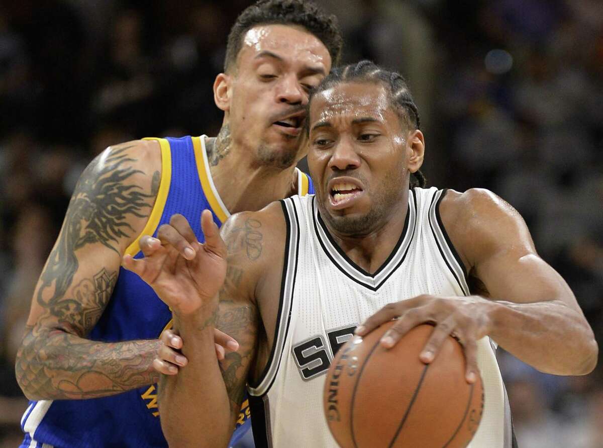 Spurs forward Kawhi Leonard drives against Golden State Warriors forward Matt Barnes during the second half on March 29, 2017, in San Antonio. Golden State won 110-98.