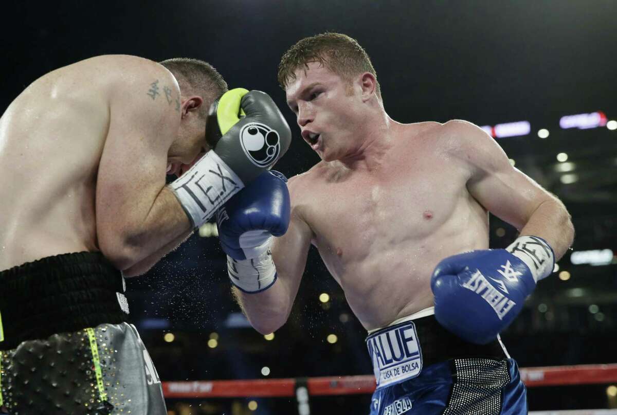 Canelo Alvarez (right) punches Liam Smith fight during the WBO junior middleweight championship boxing match at AT&T Stadium in Arlington on Sept. 17, 2016.