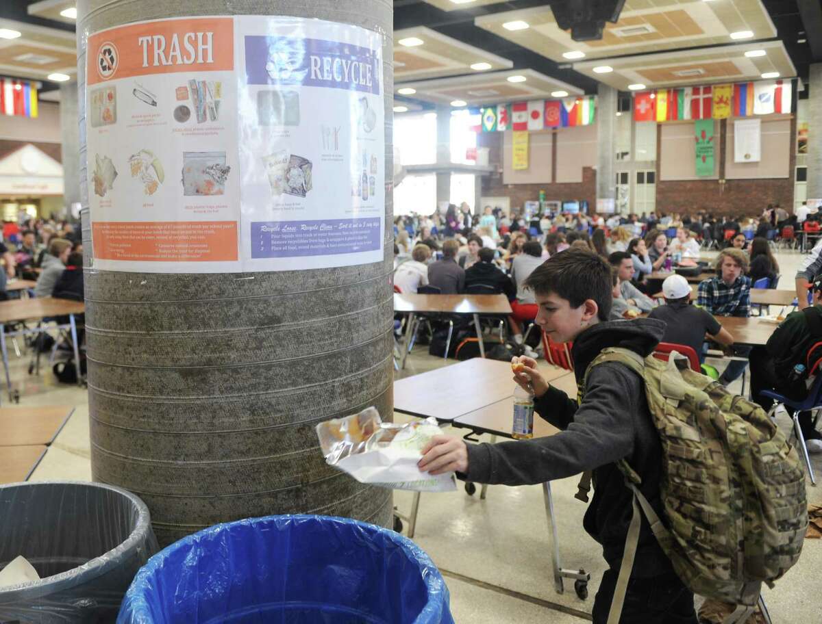 GHS freshman CJ Furano throws recyling into the bin during lunch period at Greenwich High School on March 22. The school is looking to begin composting soon.