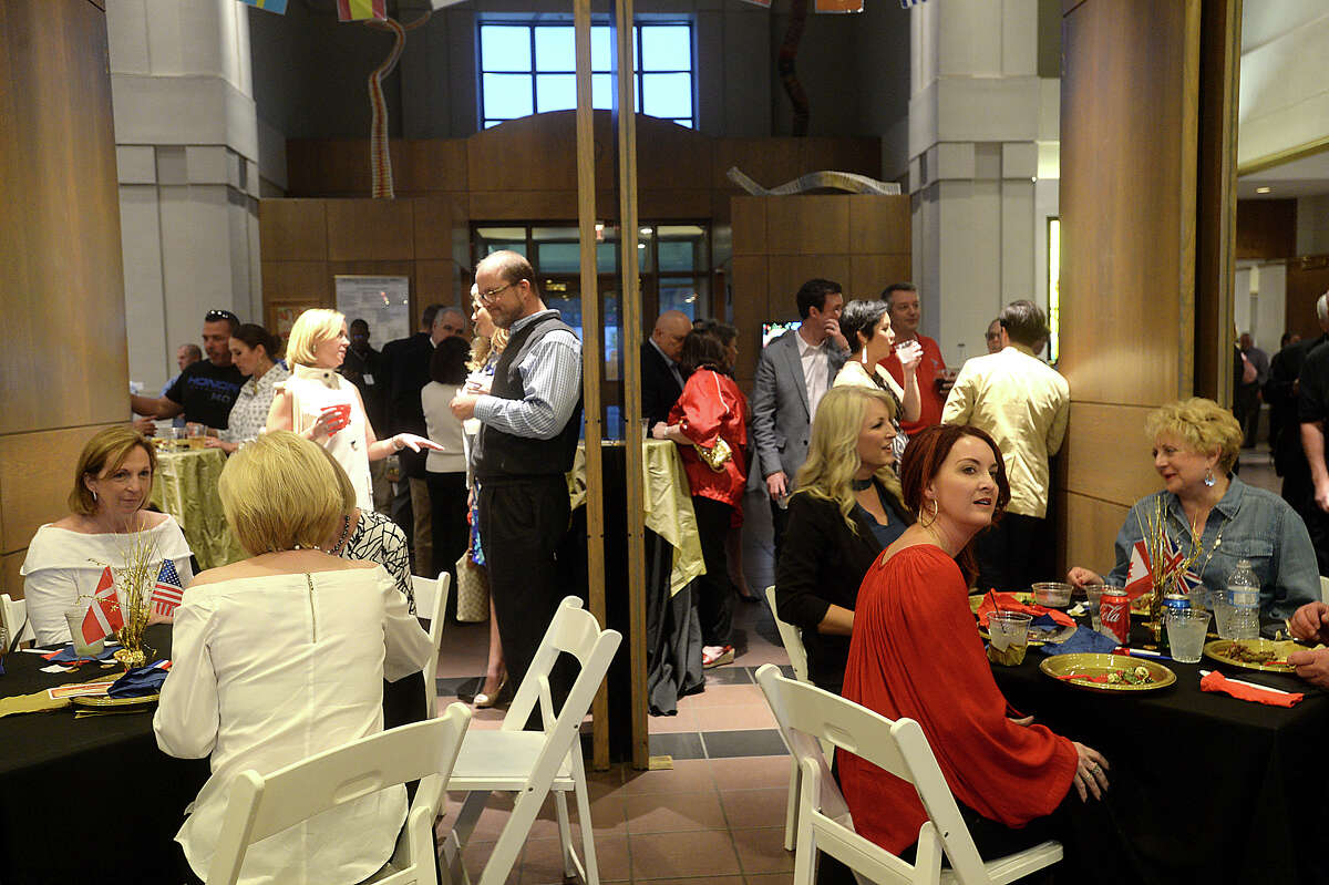 Guests socialize as they take in the raffle drawings for coins at the Art Museum of Southeast Texas' annual Go for the Gold fundraiser Thursday. This year's theme was inspired by the Olympics, with attendees encouraged to wear athletic attire as they enjoyed the festivities. Universal Coin and Bullion had gold coins on display, a glimpse of the $10,000 in gold grand prize that one lucky winner was to take home at the night's end. Photo taken Thursday, March 30, 2017 Kim Brent/The Enterprise