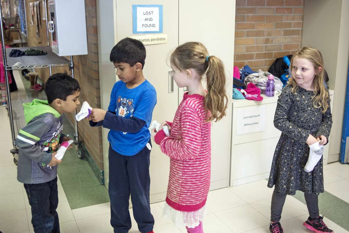 ERIN KIRKLAND | ekirkland@mdn.net From left, kindergartener Arnav Aggarwal, 5, smells classmate Vedanth Iyer's, 6, sock as fellow kindergarteners Kendra Boons, 6, and Chloe Grimm, 7, watch before attending an assembly on Tuesday at Chestnut Hill Elementary. The school collected 671 pairs of socks for SNEAKERPALOOZA, which Kurt Faust, president and founder of STEP UP and SNEAKERPALOOZA organizer, collected at the gym. "The kids wanted to take action and liked what SNEAKERPALOOZA was doing in the community," Chestnut Hill media center paraprofessional Becky Tomaszewski said. SNEAKERPALOOZA is joint effort between Success Through Education and Positive Coaching (STEP UP), Filling Midland?•s Cup, and other local churches and organizations which provides new, name-brand athletic shoes to area students. Last year, SNEAKERPALOOZA distributed over 1600 pairs of shoes to K-12 students in the area.