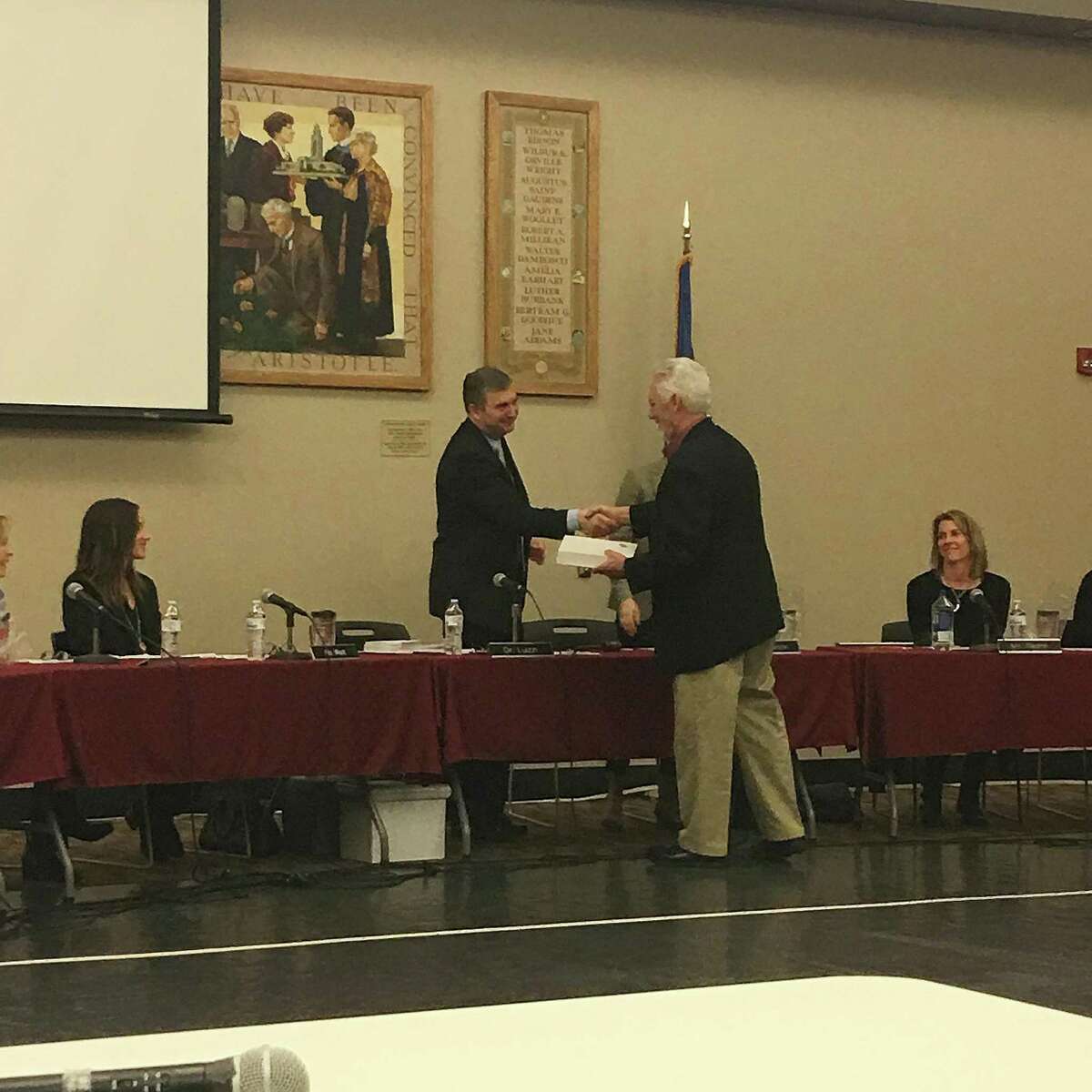 Bob Willoughby, outgoing manager of facilities operations at New Canaan, CT public schools, accepts an award of acknowledgement from superintendent Bryan Luizzi at a school board meeting on March 27, 2017.