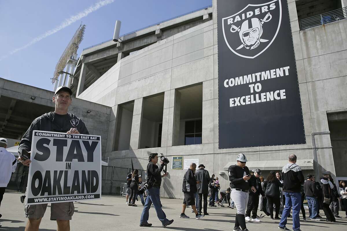 John P. Kelleher holds up a sign outside the Oakland Coliseum before the start of a rally to keep the Oakland Raiders from moving Saturday, March 25, 2017, in Oakland, Calif. NFL owners are expected to vote on the team's possible relocation to Las Vegas on Monday or Tuesday at their meeting in Phoenix. (AP Photo/Eric Risberg)