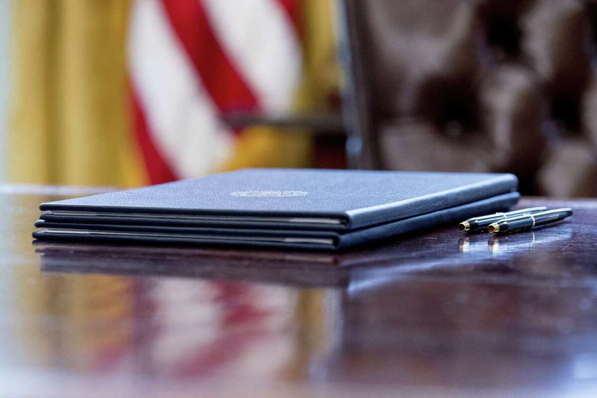 Executive orders regarding trade are placed on President Donald Trump’s desk in the Oval Office.
