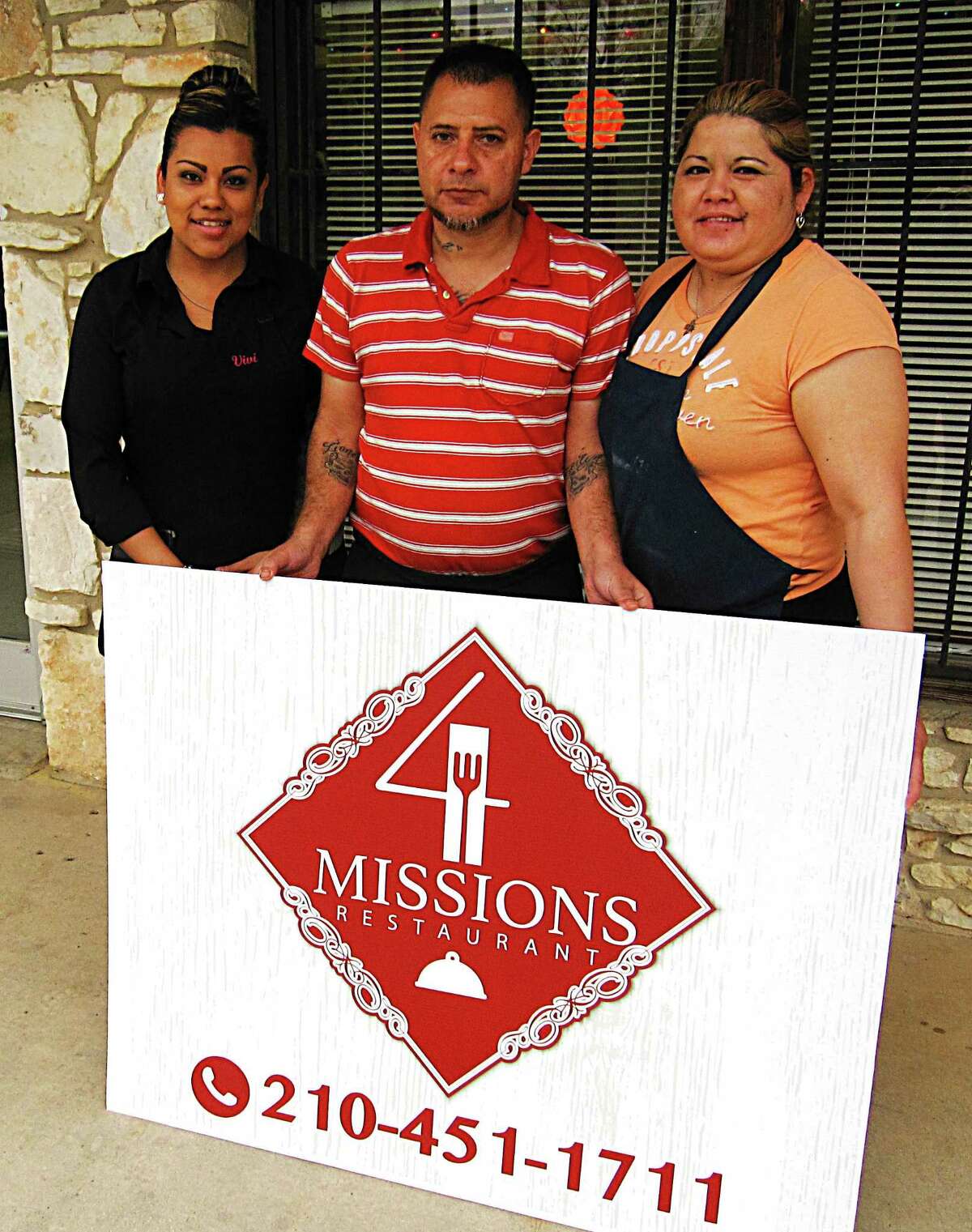 Two years after it opened, the new signs are finally ready to go up for 4 Missions Cafe. From left: server Viviana Garcia and owners Eloy and Irma Gomez.