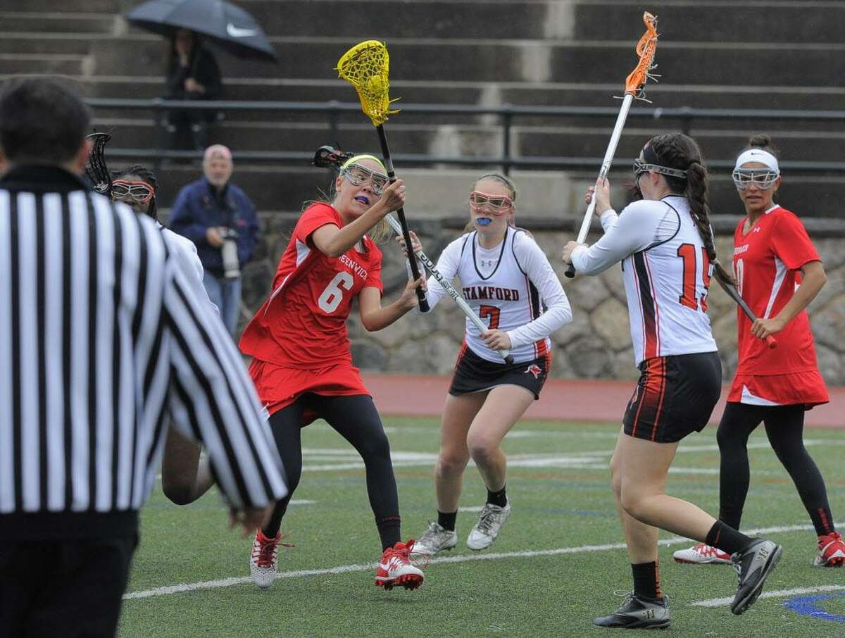 Greenwich’s Erika Bloes fires a shot on goal past Stamford’s Mackenzie Brown during a game April 26. Greenwich defeated Stamford 15-7.