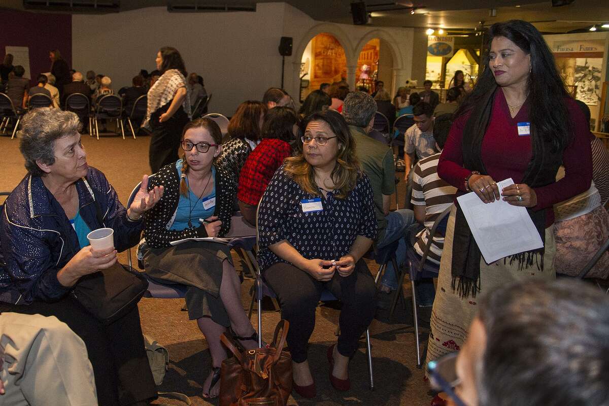 Toni Gustafson (seated left), talking with Dr. Lopita Nath (standing) as part of an event called Cultural Conversations: Refugee in San Antonio, an open discussion about issues related to the local refugee community, Monday, March 27, 2017 at the UTSA Institute of Texan Cultures.
