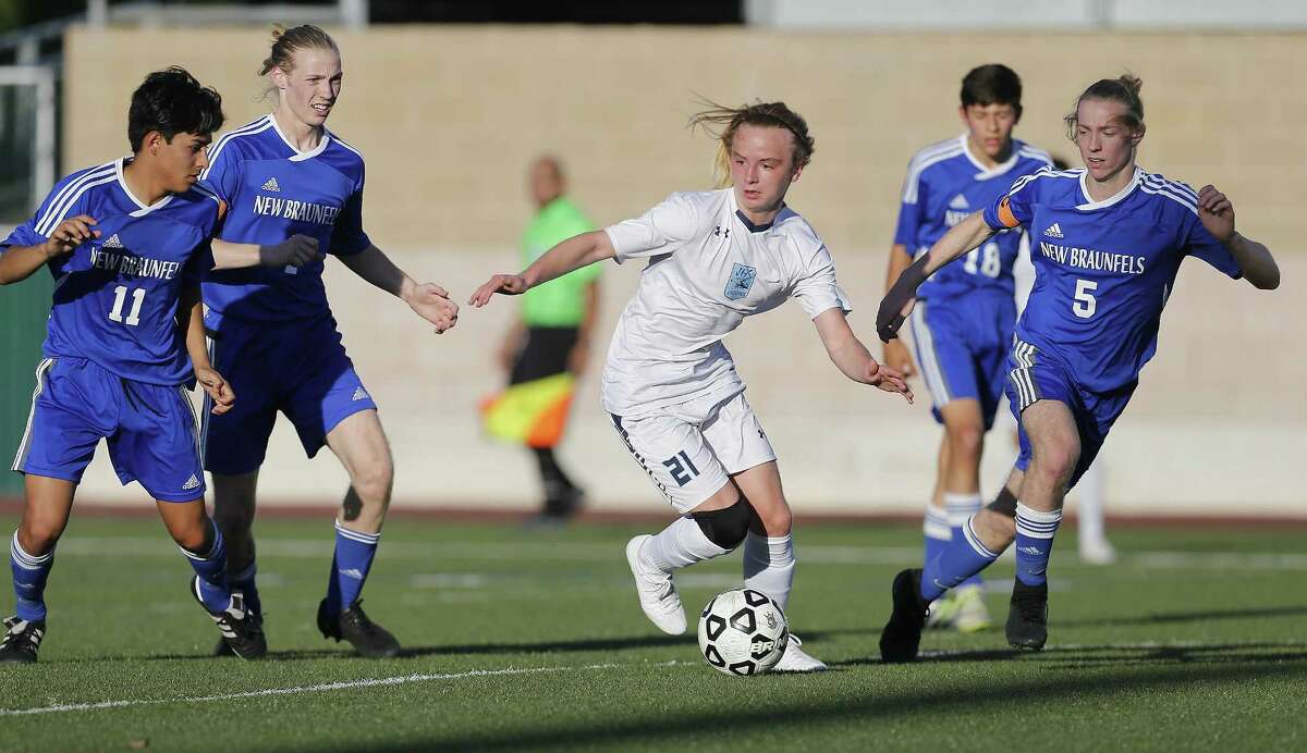 Johnson’s Ashton Bynum (21) looks to manuever around New Braunfels defenders in 6A second-round boys soccer at Farris Stadium on March 31, 2017.