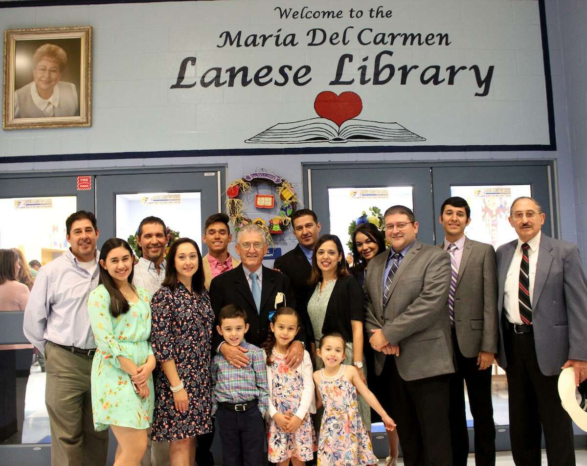 The Maria Del Carmen Lanese family joins in the unveiling of the portrait and lettering that will be in the front entrance of the library.