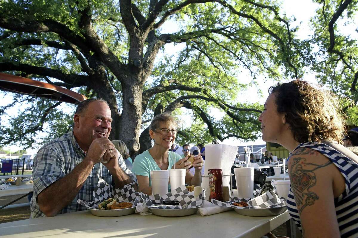 Mark and Laura Balencia share some food at the Den reastaurant with Jessica Drewry (right) under the site's ancient old oak tree in La Vernia on March 31, 2017.