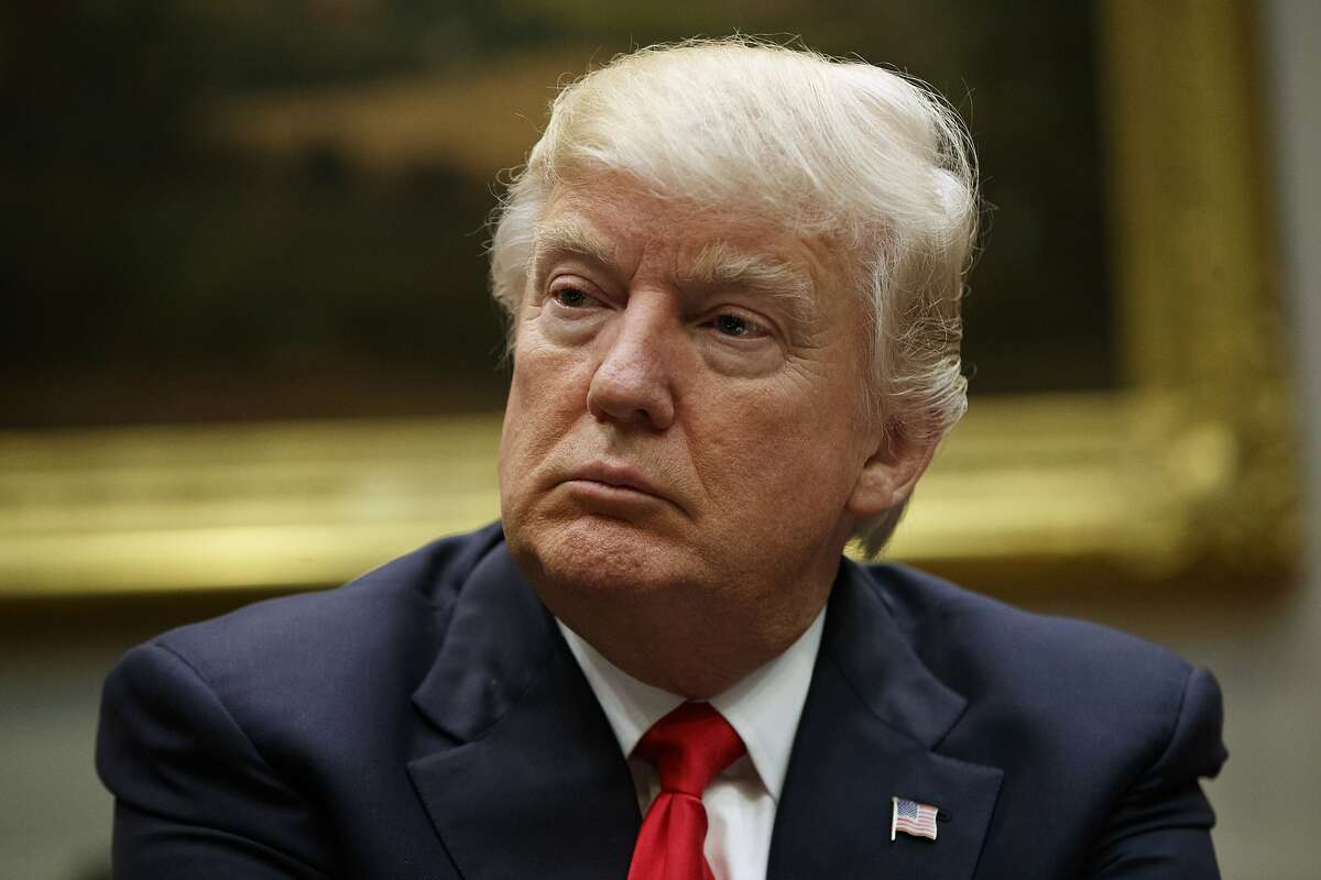 In this March 31, 2017, photo, President Donald Trump listens during a meeting with the National Association of Manufacturers in the Roosevelt Room of the White House in Washington. Slim majorities of Americans favor independent investigations into Trump’s relationship with the Russian government and possible attempts by Russia to influence last year’s election according to a new poll by The Associated Press-NORC Center for Public Affairs Research. (AP Photo/Evan Vucci)