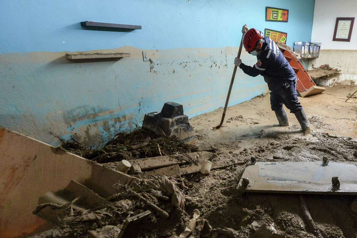 A fireman searches for victims inside a muddy house, following mudslides caused by heavy rains in Mocoa, Putumayo department, southern Colombia on April 2, 2017. The death toll from a devastating landslide in the Colombian town of Mocoa stood at around 200 on Sunday as rescuers clawed through piles of muck and debris in search of survivors. / AFP PHOTO / LUIS ROBAYOLUIS ROBAYO/AFP/Getty Images