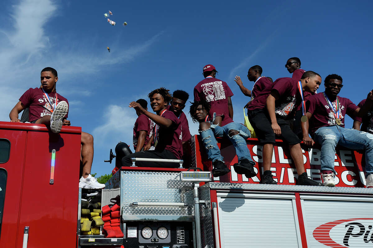 Silsbee basketball players toss candy to the crowd during a parade celebrating the team's state championship on Saturday. Photo taken Saturday 4/1/17 Ryan Pelham/The Enterprise