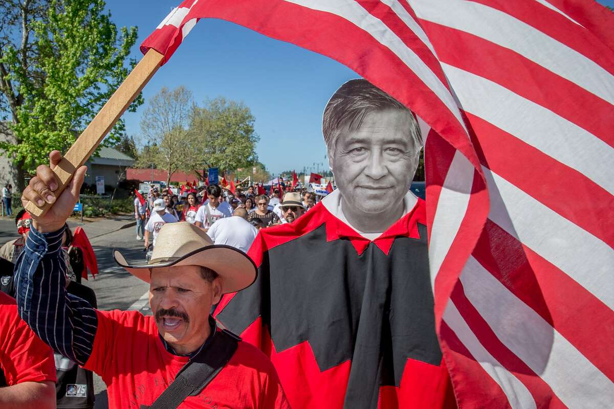 Guadalupe Suarez waves the American flag during a march for Cesar Chavez on Sunday, April 2, 2017, in Santa Rosa, Calif.