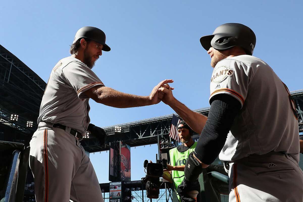 PHOENIX, AZ - APRIL 02: Madison Bumgarner #40 of the San Francisco Giants high fives Hunter Pence #8 after Bumgarner hit a solo home run against the Arizona Diamondbacks during the seventh inning of the MLB opening day game at Chase Field on April 2, 2017 in Phoenix, Arizona. (Photo by Christian Petersen/Getty Images)