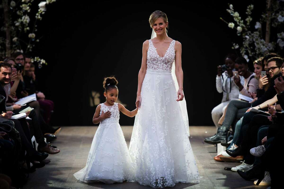 A model and a girl present creations by Cymbeline Wedding Dresses house, on April 1, 2017 in Paris. The Connecticut Better Business Bureau has some tips for negotiating the high costs and high stress of wedding planning. / AFP PHOTO / MARTIN BUREAUMARTIN BUREAU/AFP/Getty Images