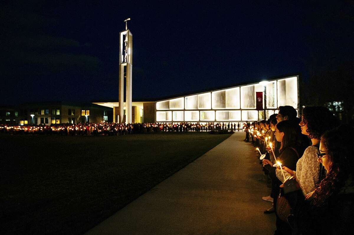 FILE: In this April 2, 2017 photo released by Sacred Heart University, students participate in a candlelight vigil in memory of student Caitlin Nelson on the school's campus in Fairfield, Conn. Police said Nelson, from Clark, N.J., died days after choking during a pancake-eating contest at the college.