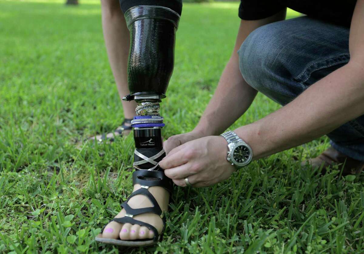 Rebekah Gregory gets a little help adjusting the bling on her prosthesis outside her home on Monday, March 27, 2017, in Fulshear, Texas. Gregory lost her leg as a result of injuries sustained in the Boston Marathon Bombing. ( Elizabeth Conley / Houston Chronicle )
