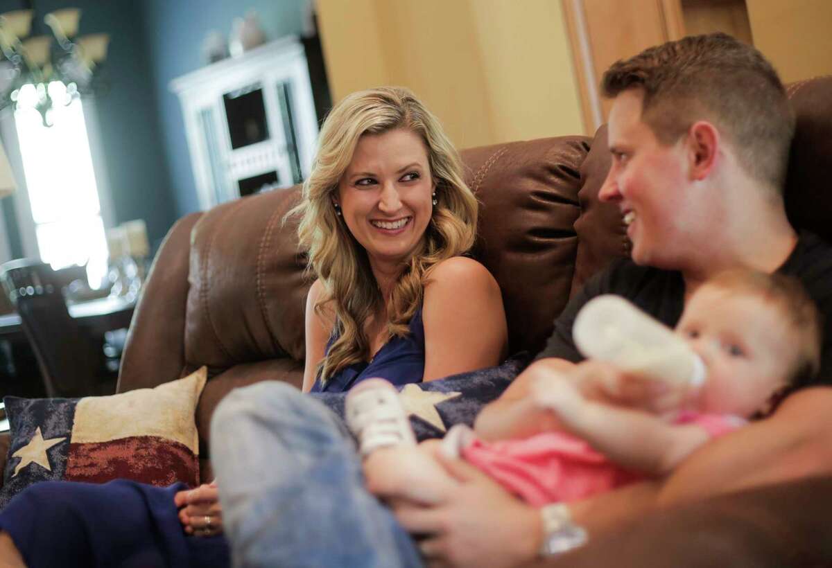 Rebekah Gregory smiles at her husband, Chris, as he feeds their daughter, Ryleigh, in their home on Monday, March 27, 2017, in Fulshear. ( Elizabeth Conley / Houston Chronicle )