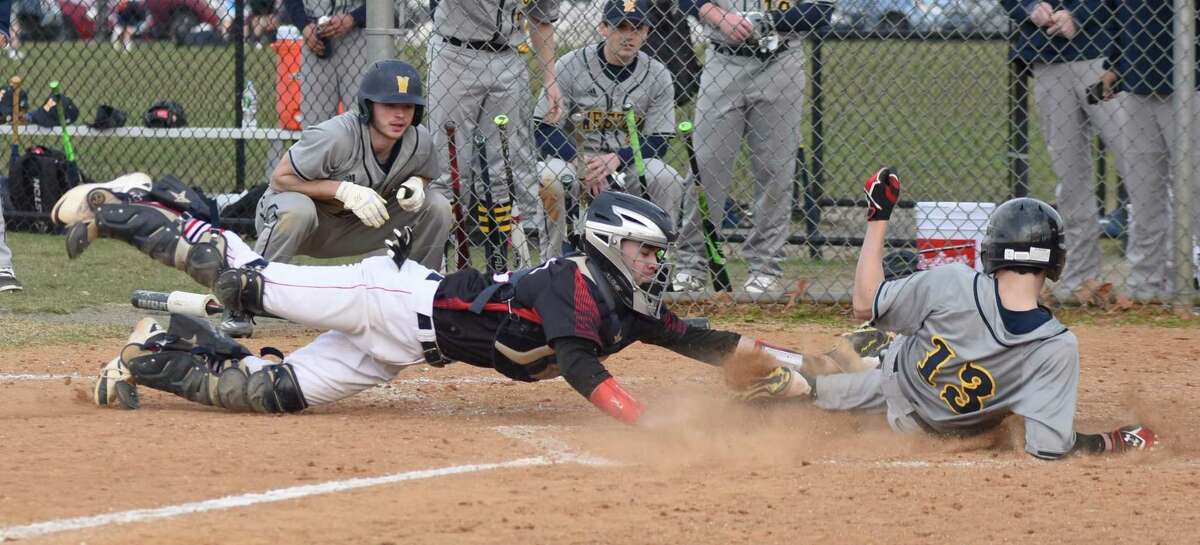 Fairfield Warde catcher Finn Mobley, left, dives to tag Weston's Will Vallela during a play at the plate in the sixth inning of Monday's non-conference high school baseball game in Fairfield. Vallela was safe on the play as Weston went on to post a 13-3 win.