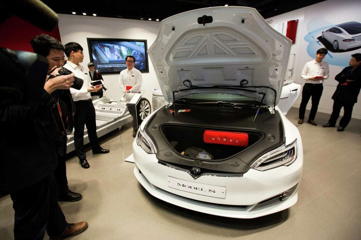 Members of the media check out a Tesla Model S 90D electric vehicle last month at the company's showroom in Hanam, South Korea. Tesla's value on Monday surpassed that of Ford Motor Co.﻿