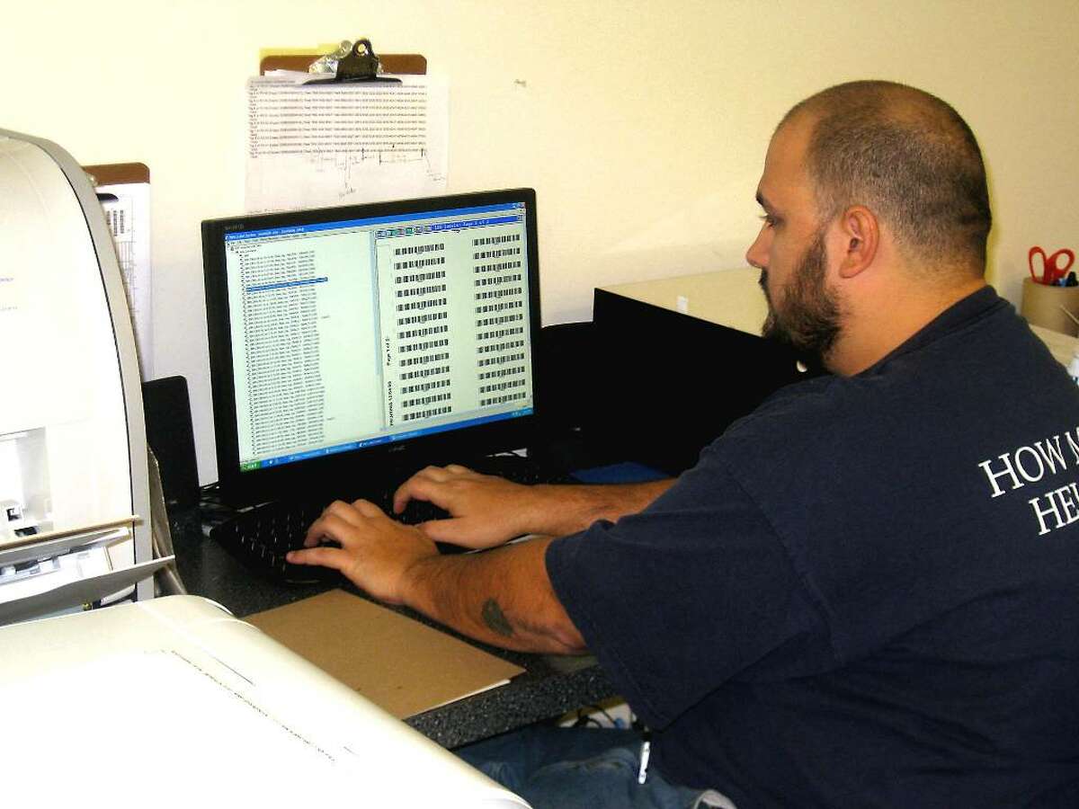 Joe Cuzino, a radio frequency ID specialist with Netc LLC, creates RF ID labels for placement on magnetic tape in the Trumbull-based facility's production room.