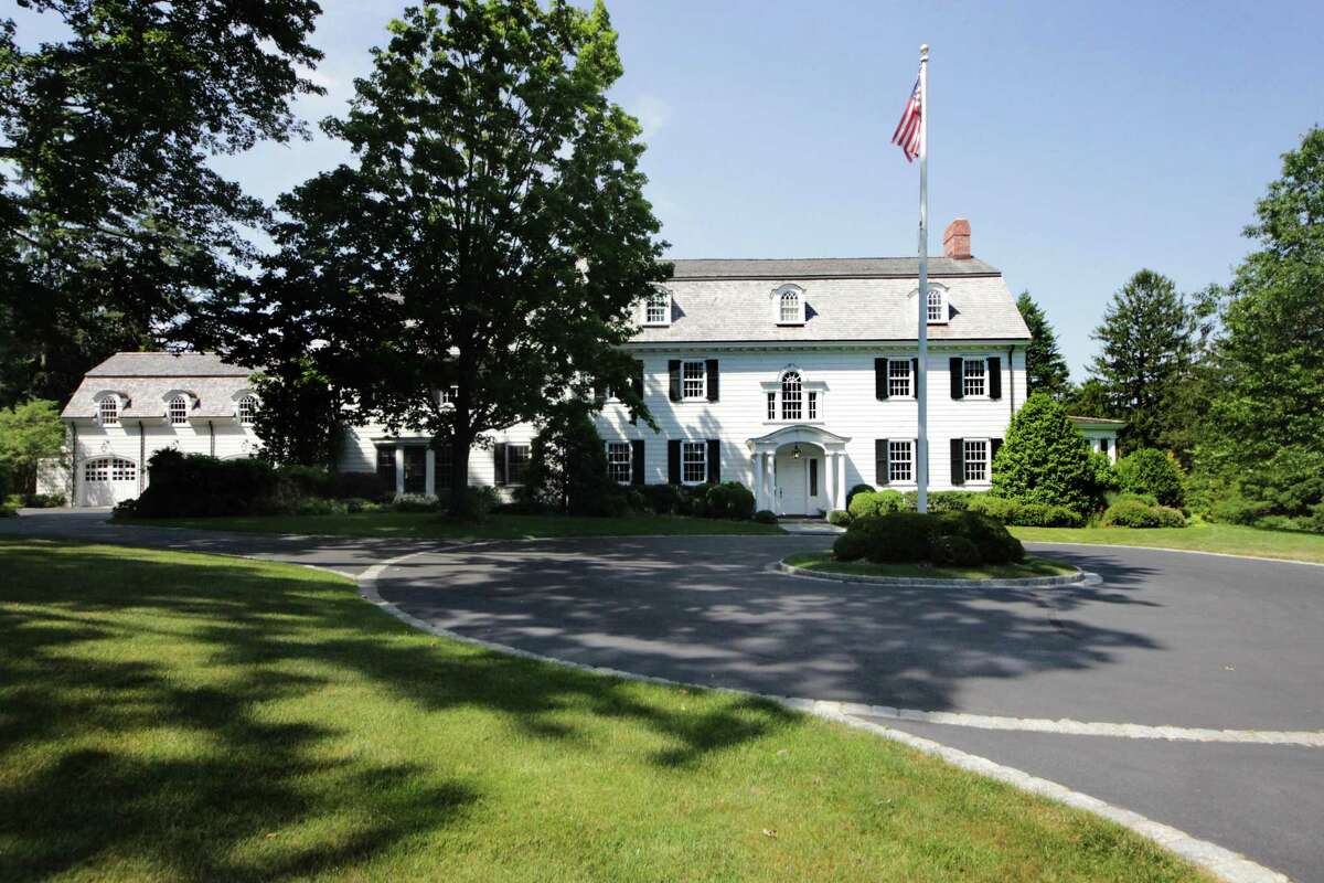 The white shingle house with black shutters at 81 Canoe Hill Road looks like a classic colonial from the street view but lives like a modern home. It has long circular driveway lined in Belgium block with a flag pole.