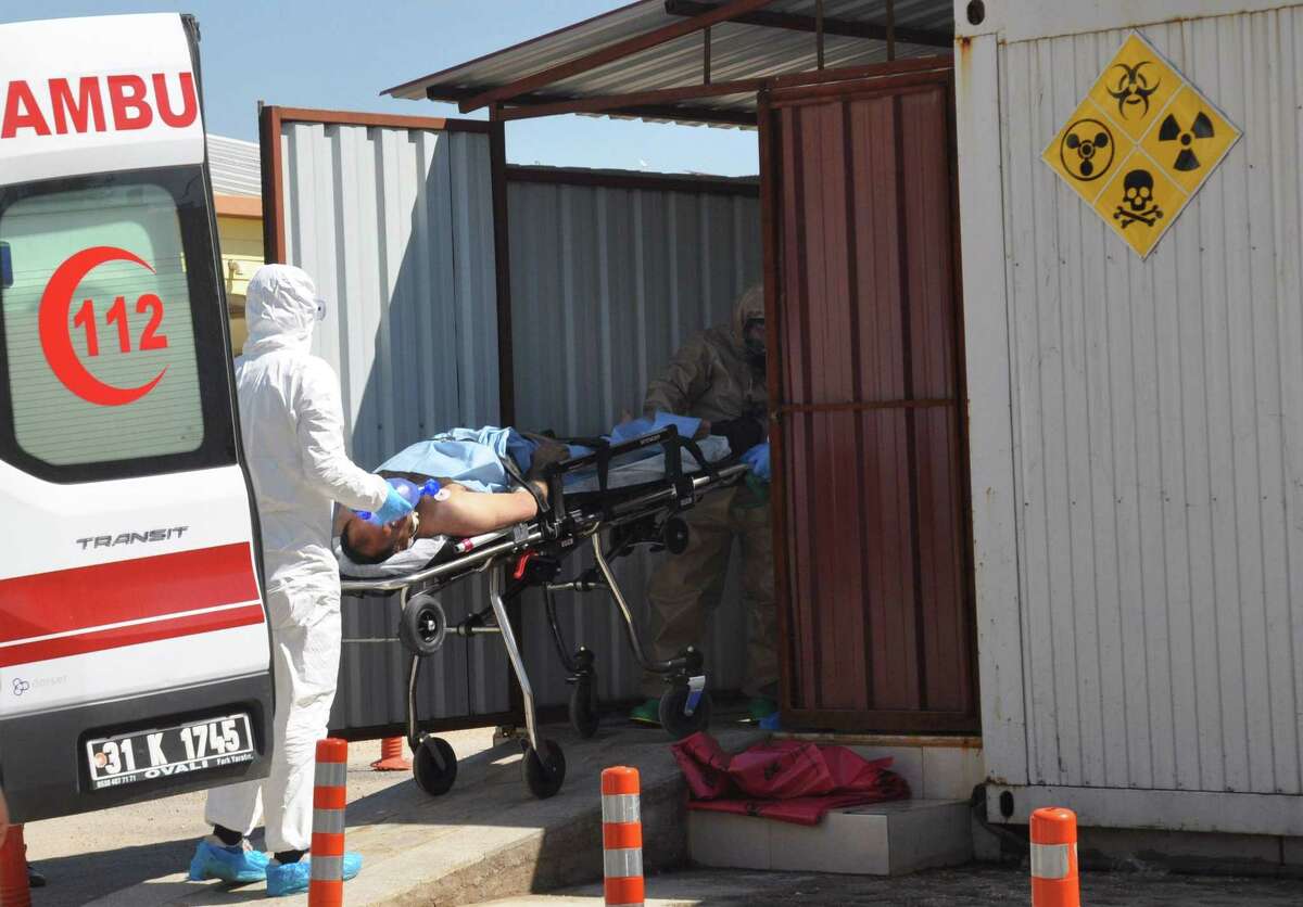 Turkish officials with chemical clothes carry a injured man on April 4, 2017 in Hatay, near the Syrian border. Turkish President Recep Tayyip Erdogan in a phone call with Russian counterpart Vladimir Putin on April 4, 2017 condemned a suspected chemical attack in northwestern Syria as an "inhuman" strike that could endanger peace talks based in the Kazakh capital. / AFP PHOTO / DOGAN NEWS AGENCY / - / Turkey OUT-/AFP/Getty Images